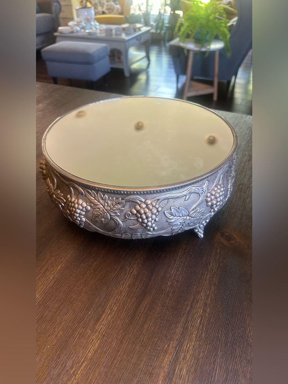 11.5” diameter, silver tone cake stand on feet with mirror and  grape vine desig